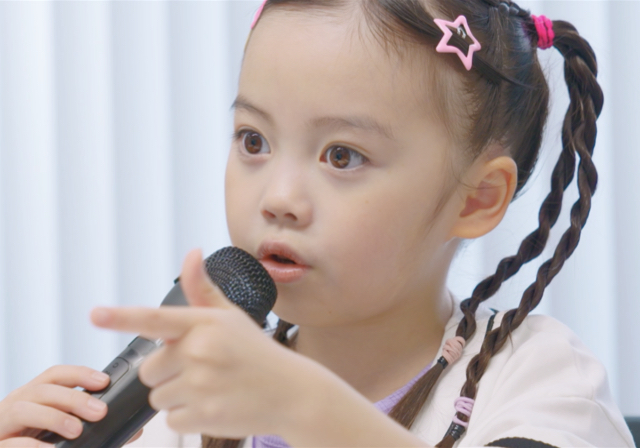 マイクを持ち指をさす審査員